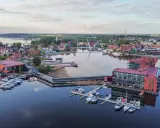 Nowoczesna wieża widokowa Mazury góruje nad jeziorem z mariną pełną łodzi.