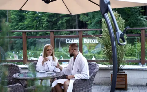 Para młoda w szlafrokach pije kawę na tarasie. Idealne miejsce na podróż poślubną w Polsce.