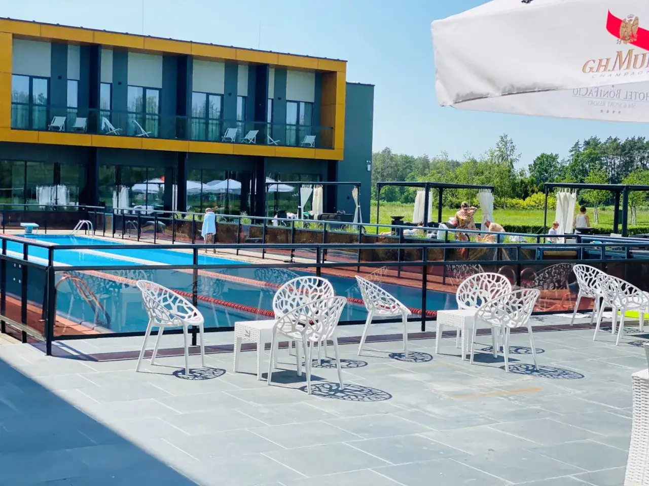 Basen i leżaki przy nowoczesnym hotelu – idealne na fajne miejsca niedaleko Warszawy na weekend.